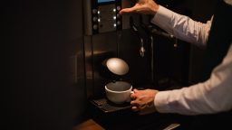 Prepararea unei cafele la un automat de cafea profesional pentru birou